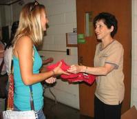 President Cordova presents a student with a tee shirt