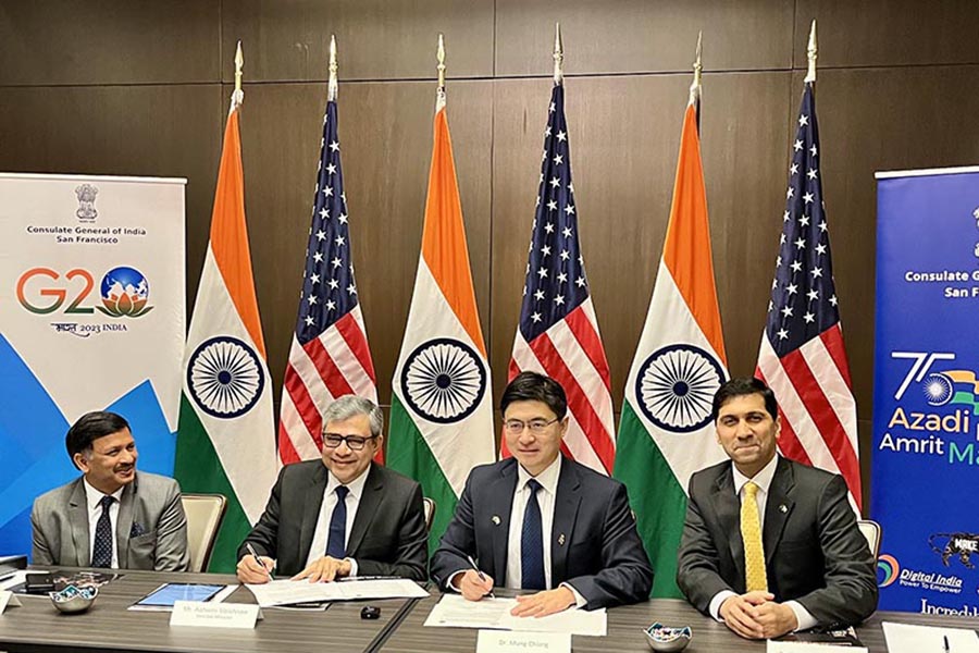 Nagendra Prasad, Consul General of the Indian Consulate in San Francisco; Honorable Ashwini Vaishnaw, India's Union Minister for Railways, Communications, Electronics and IT; Purdue President Mung Chiang; and Vijay Raghunathan, Purdue professor and Associate Head of Electrical and Computer Engineering and Director of Semiconductor Education for Purdue are seatied at a long table and facing the camera. Behind them are Indian and  US flags. 