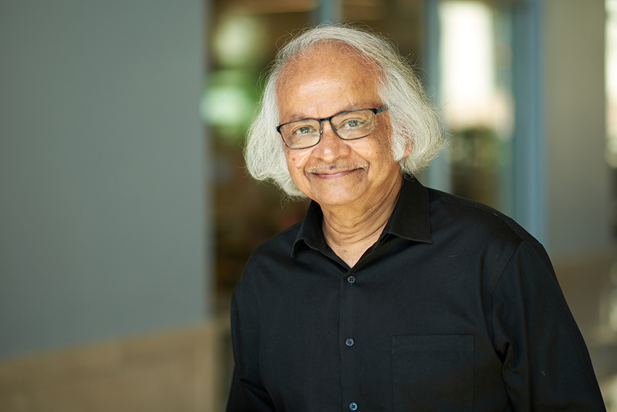 Portrait of Supriyo Datta in the atrium of the MSEE buliidng. He is wearing a black shirt and glasses.