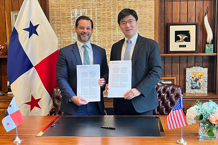 Two men dressed in suits hold papers, standing before flags, indicating a formal negotiation or partnership