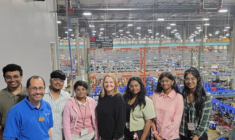 Students inside building with factory equipment