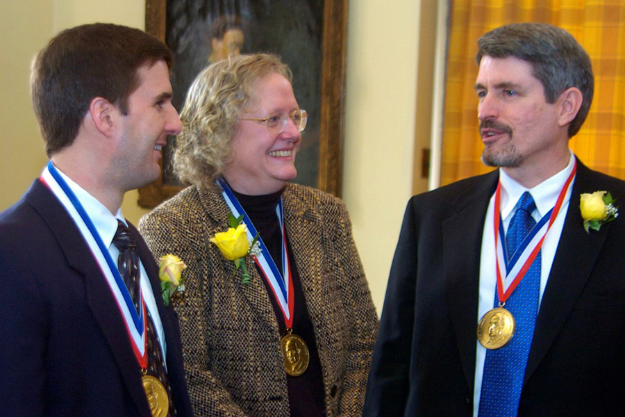 Three people wearing medals