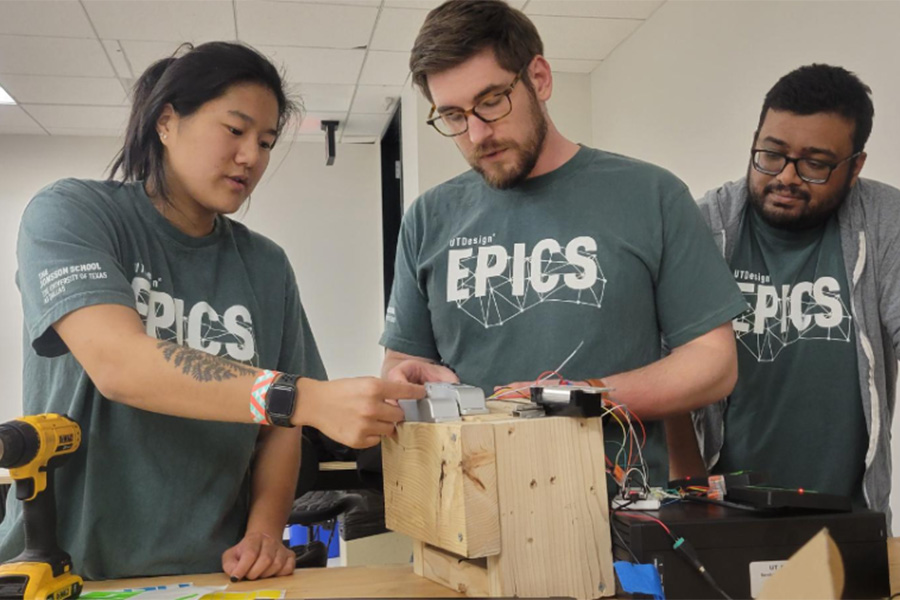 Students wearing gray shirts that say UTD EPICS, working on a project