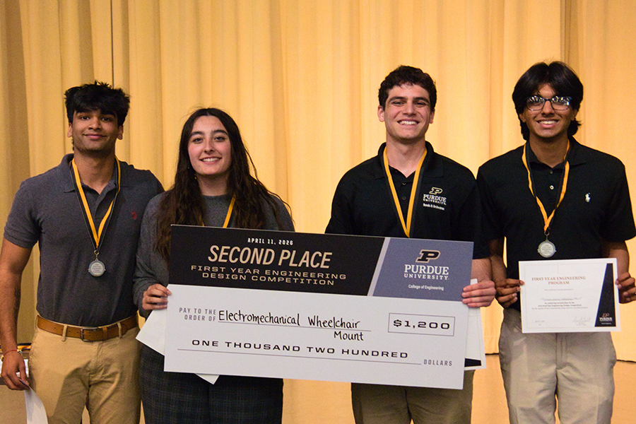 Students smiling holding a big check