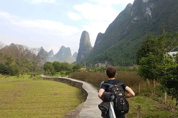 Student running down a long mountainous path