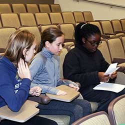 Girls fold paper airplanes in an assembly line