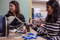 Students, Zhang and Suresh, work on assistive technologies