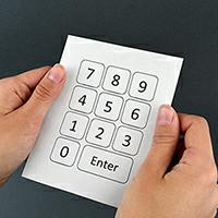 Hands holding a number keypad printed on paper
